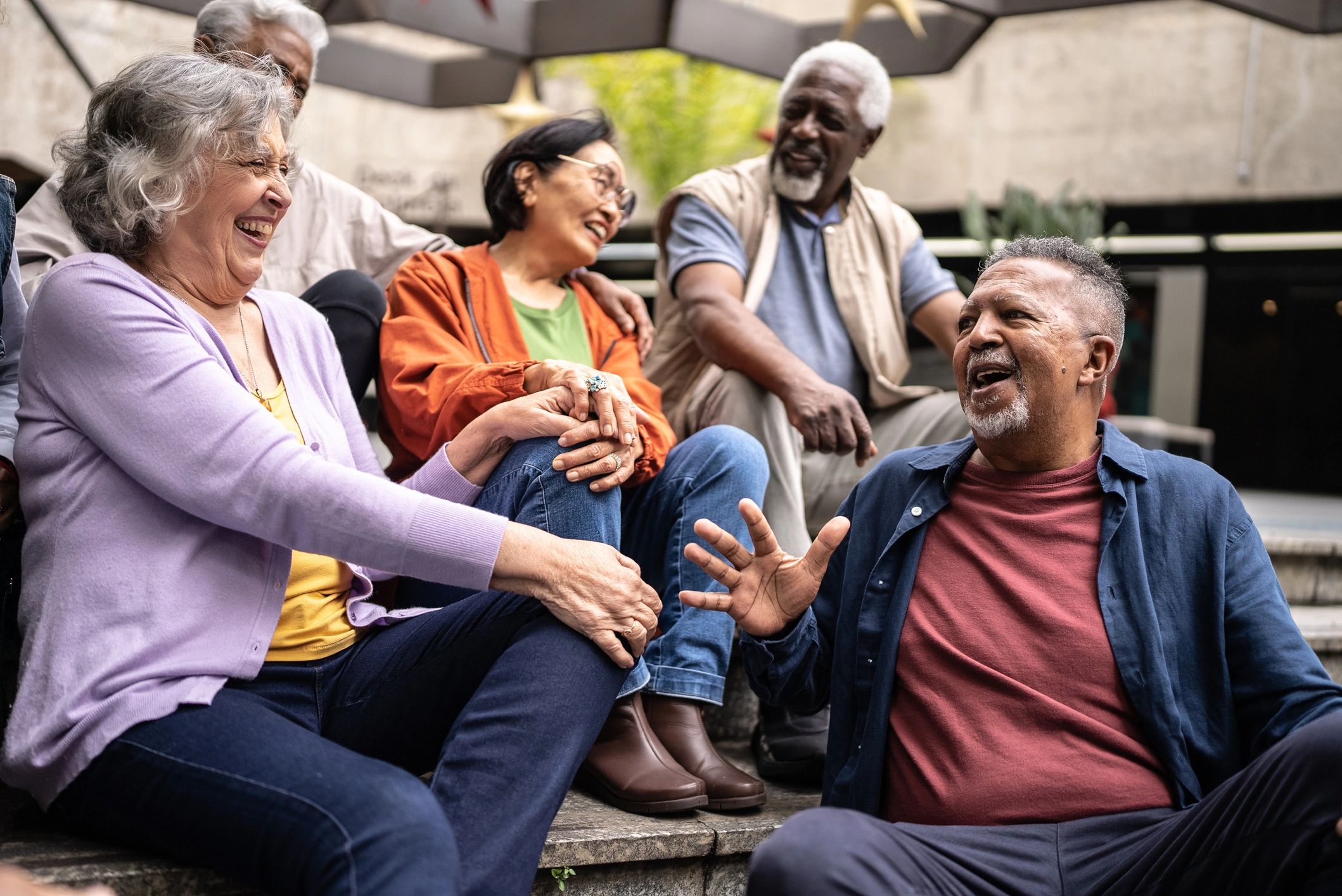 Older adults chatting together outdoors in a garden setting