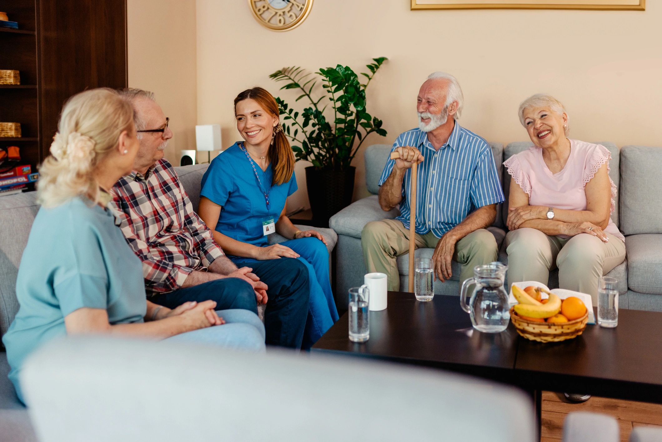 Seniors and a caregiver in a supportive group setting at a care home