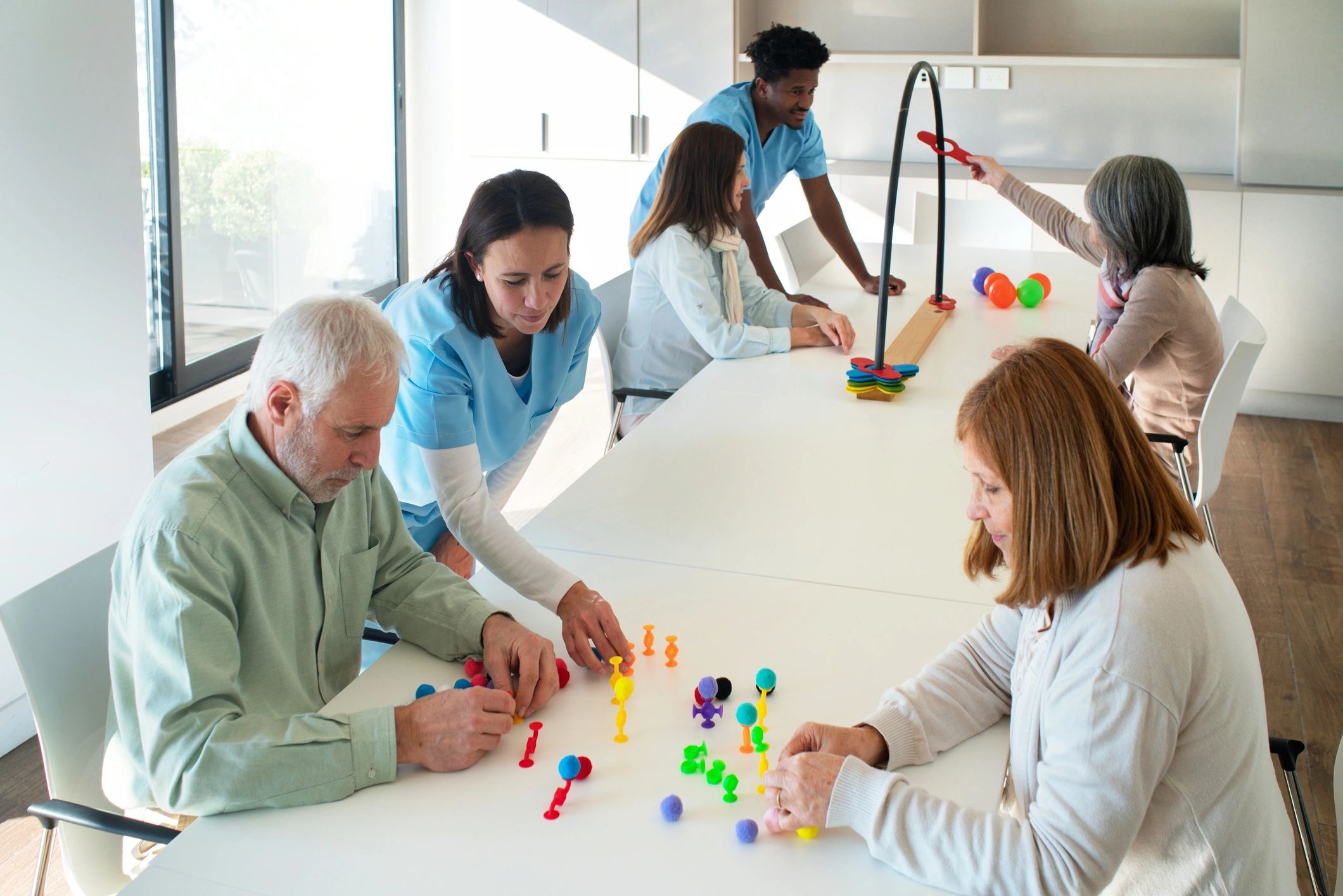 Care staff guiding residents through a hands-on activity.