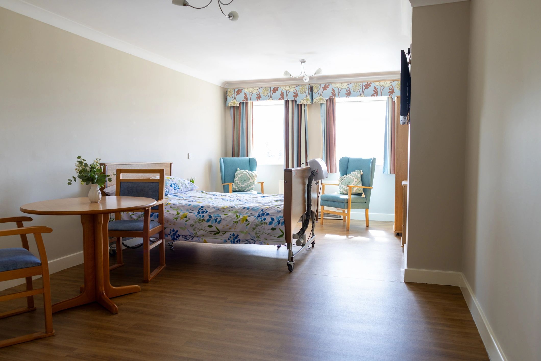 Bright, well-presented care home bedroom with seating area