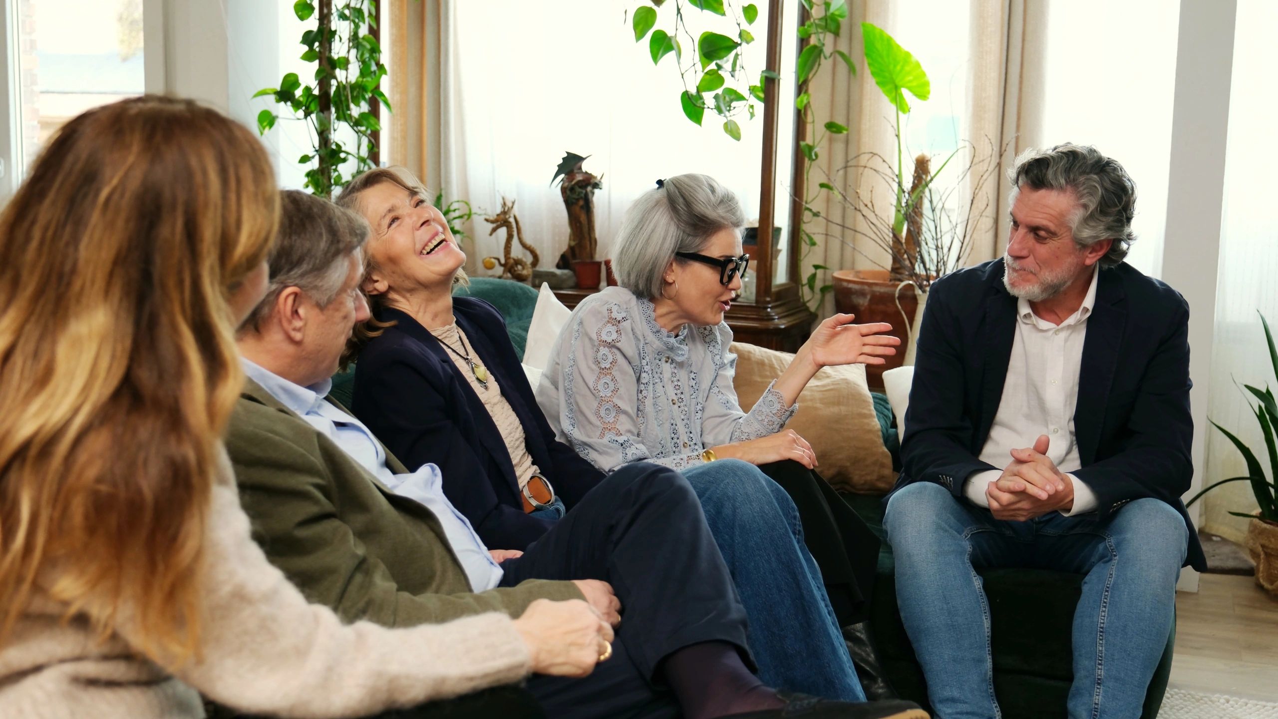 Senior friends laughing together on a sofa