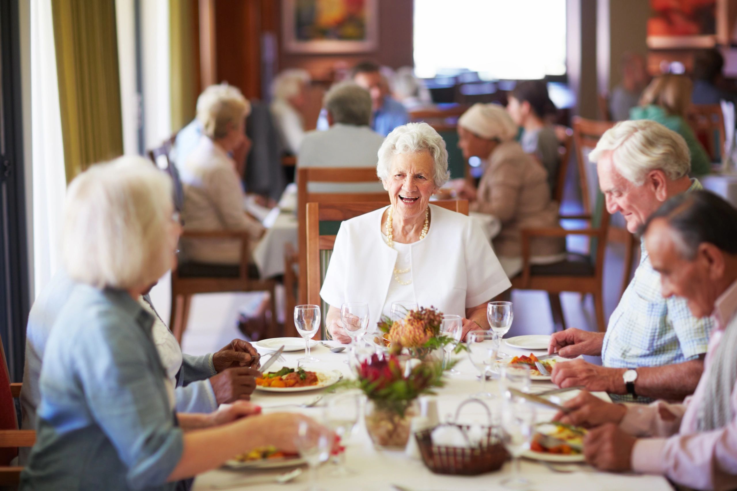 Residents enjoying lunch together at a care home dining table