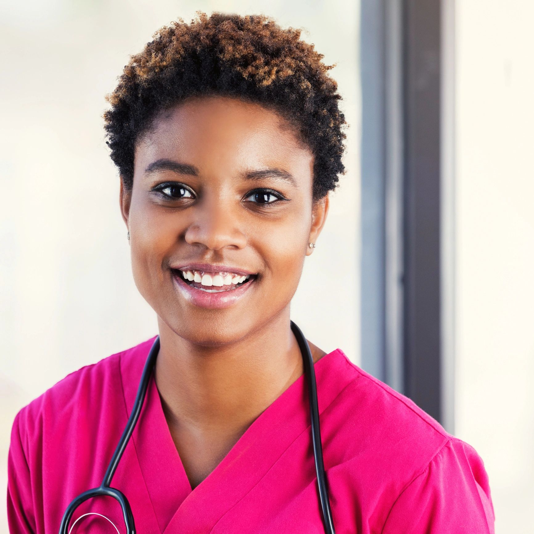 Portrait of a nurse in pink scrubs smiling